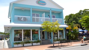 A two-story building with a blue and white exterior, a balcony, and a sign that reads "Gidget's Coastal Preserve." - Siesta Heron 3 (Siesta Key)