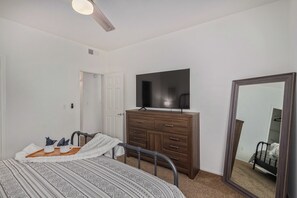 A bedroom with a bed, a dresser, a television, and a mirror. - Sahuaro #2035 Scottsdale (Scottsdale)