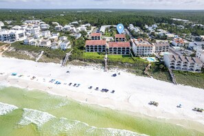 An aerial view of a coastal town with a beach, a large resort building, and surrounding residential areas. - Palms of Seagrove D5 (Santa Rosa Beach)