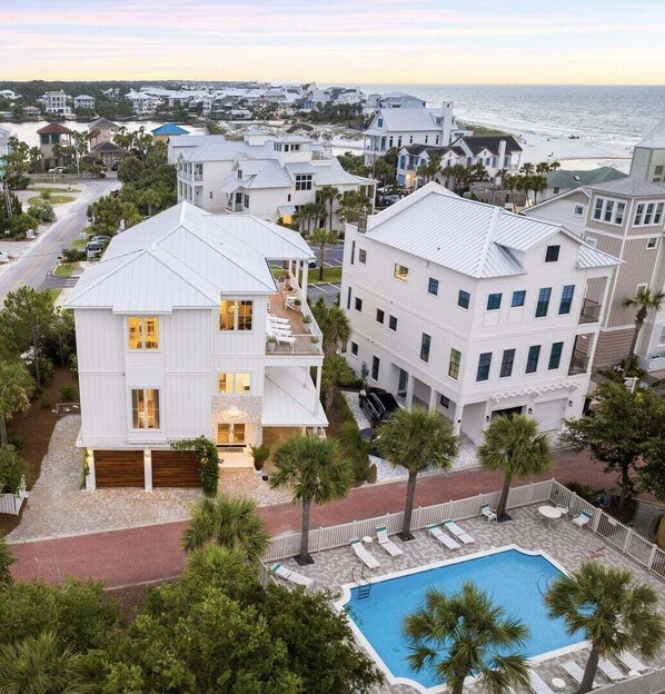 A coastal residential area with white buildings, a swimming pool, and a view of the ocean. - Salt & Light (Santa Rosa Beach)