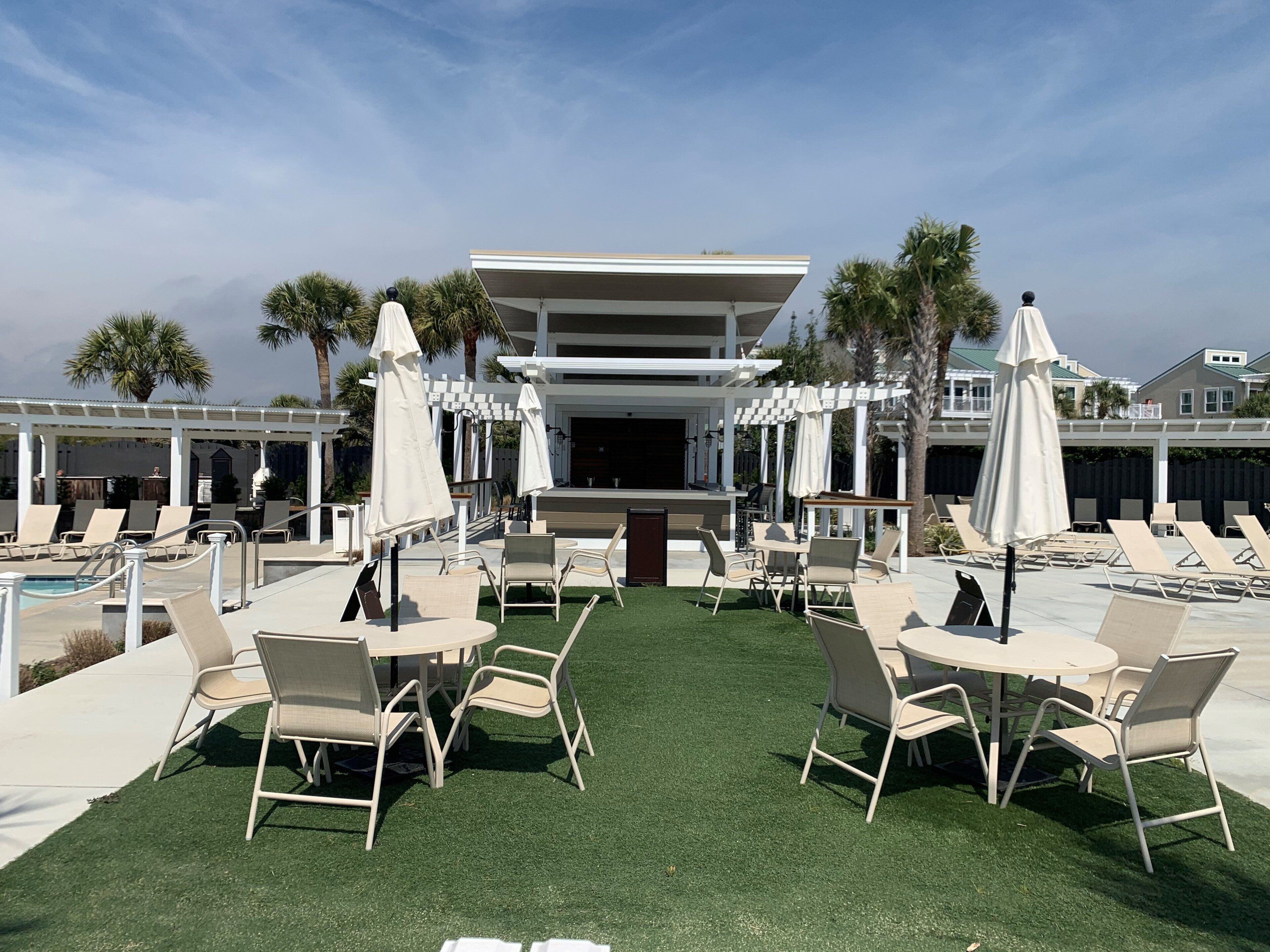 A poolside area with outdoor seating and a covered bar area.