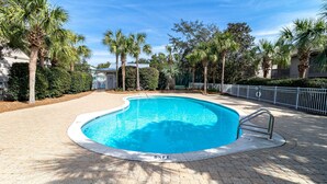 A swimming pool with a 5½ ft depth, surrounded by palm trees and a paved walkway. - Somewhere in the Sun (Santa Rosa Beach)