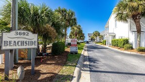 A street view with a '3692 BEACHSIDE' sign, a 'TOWN AWAY ZONE' sign, and a 'BEACHSIDE CONDOS' sign indicating condos available for rent by permit only. - Seagroovy (Santa Rosa Beach)