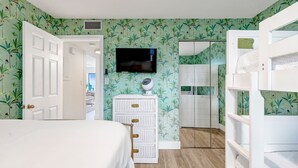 A bedroom with a bunk bed, a dresser, a television, and a wardrobe. - Seagroovy (Santa Rosa Beach)