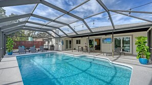 A covered swimming pool with clear water, surrounded by lounge chairs and a patio area. - Modern Spacious 3 Bedroom, 2 Bathroom Private Pool Home in Sarasota Near Siesta Key (Sarasota)