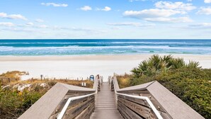 A wooden staircase leading to a beach with a clear view of the ocean. - Serenity Now (Santa Rosa Beach)