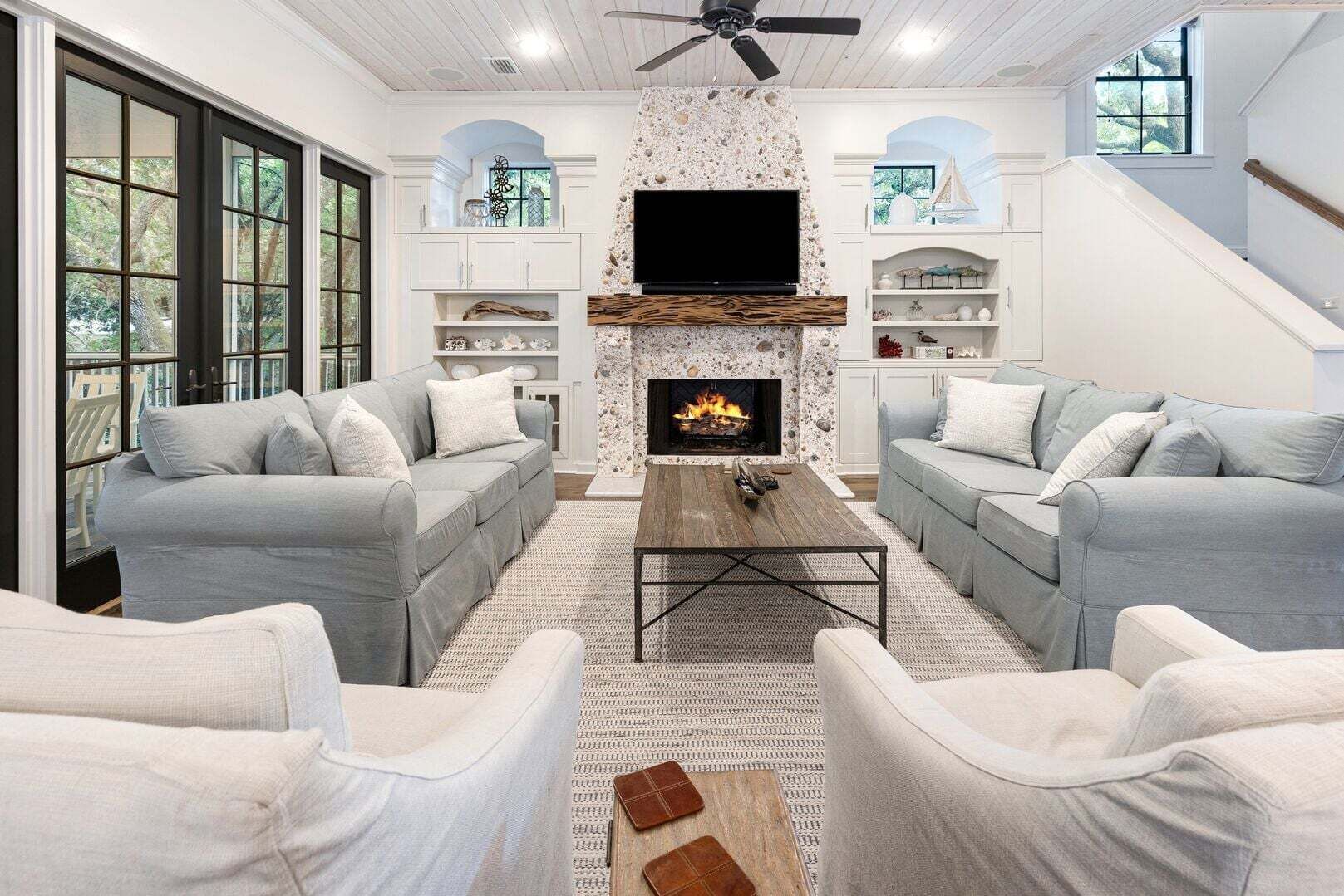 Una sala de estar con chimenea, dos sofás, una mesa de centro y un televisor.
