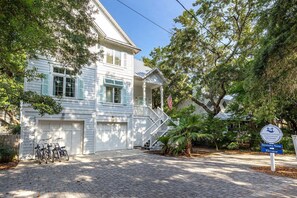A white building with a porch, a staircase, and a sign indicating 'Elevator' and 'Serenity Now.' - Serenity Now (Santa Rosa Beach)