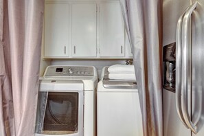 A compact kitchen with a washing machine, dryer, and a refrigerator. - Osborn (Scottsdale)