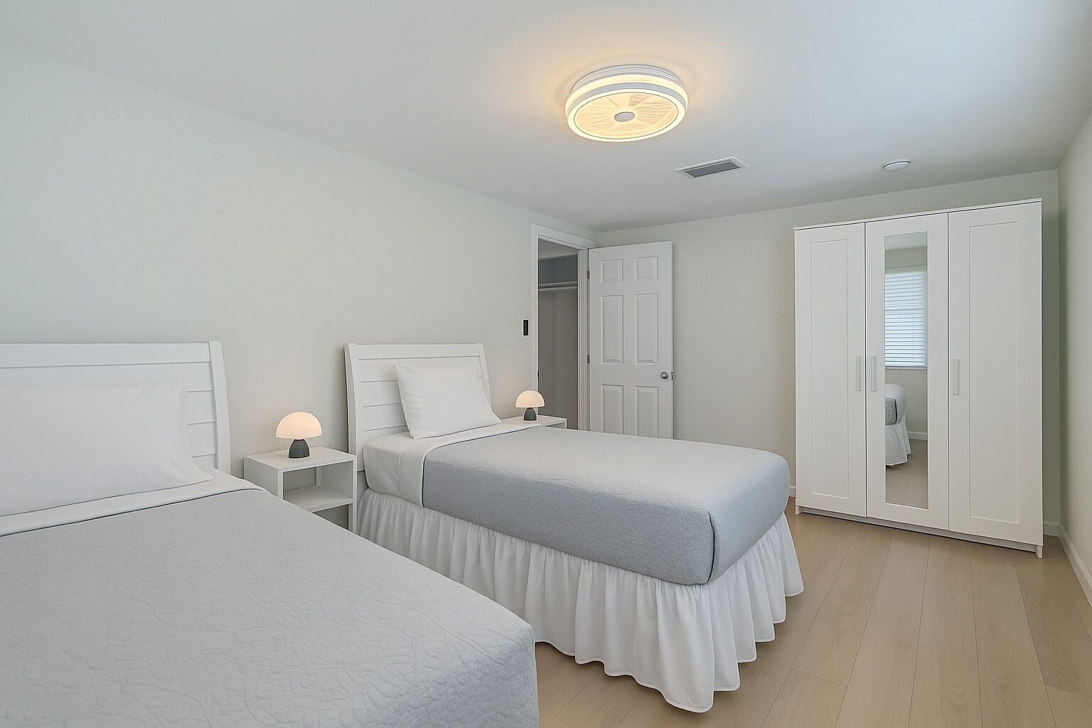 A bedroom with two beds, a wardrobe, and a ceiling light.