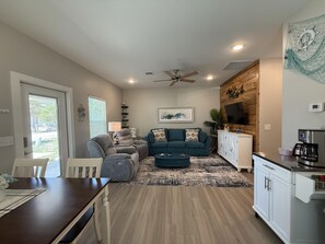 A living room with a sofa, chairs, a coffee station, and a TV. - Free Bird @ The Oasis | Relaxed Coastal Cottage Retreat (Rockport)