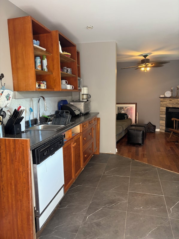 A kitchen with wooden cabinets, a dishwasher, a microwave, and a coffee maker.