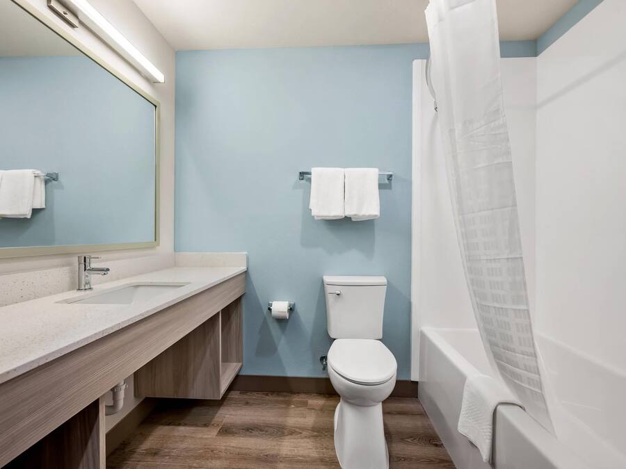 A bathroom with a sink, mirror, toilet, and bathtub.