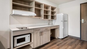 Una cocina equipada con microondas, estufa, lavaplatos y refrigerador.