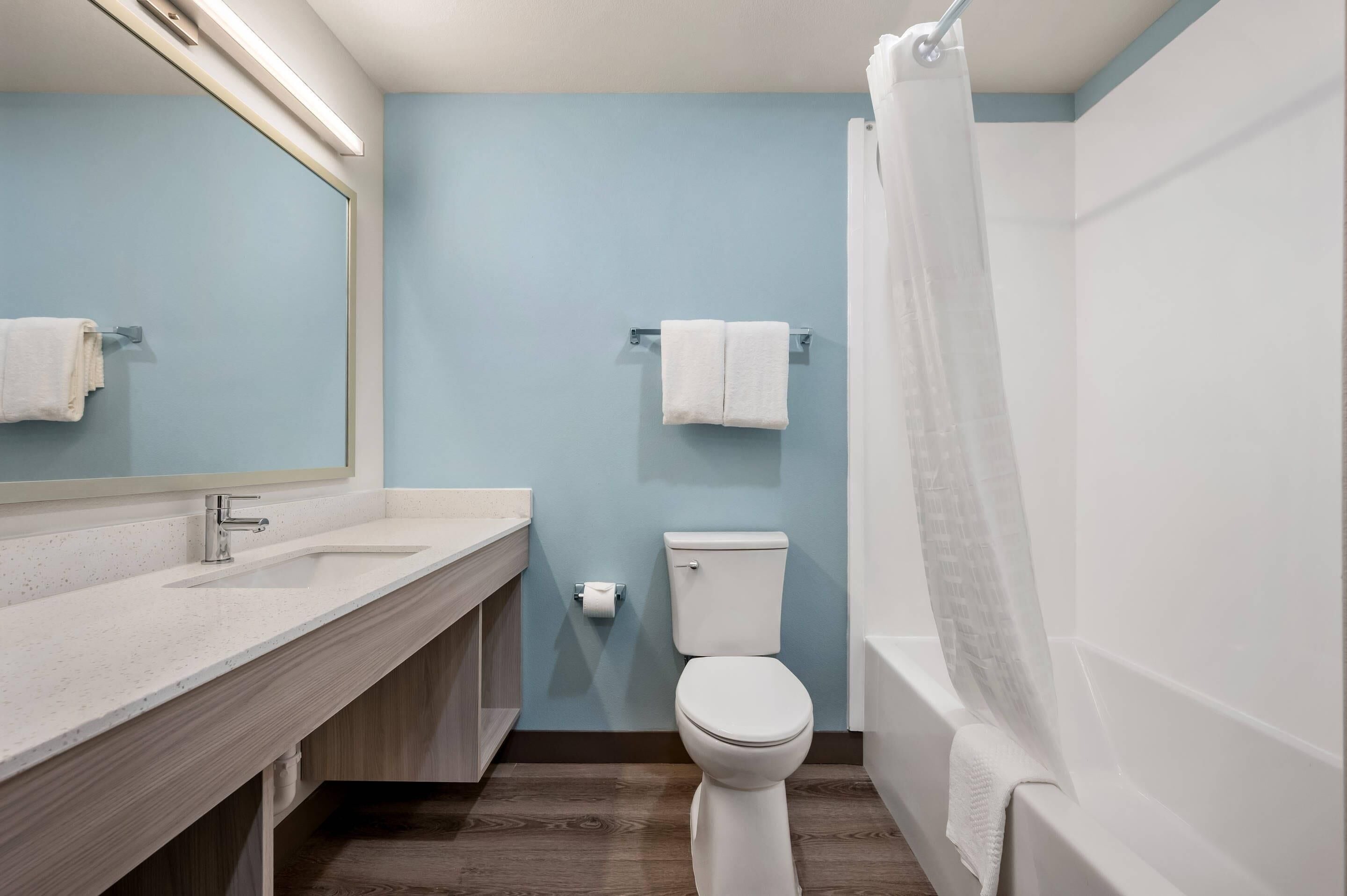 Un bagno con lavandino, specchio, wc e vasca da bagno bianchi.