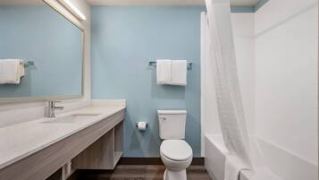 Un bagno con lavandino, specchio, wc e vasca da bagno bianchi.