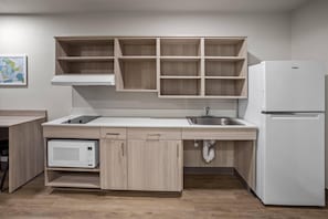 A kitchen with a microwave, sink, and refrigerator.