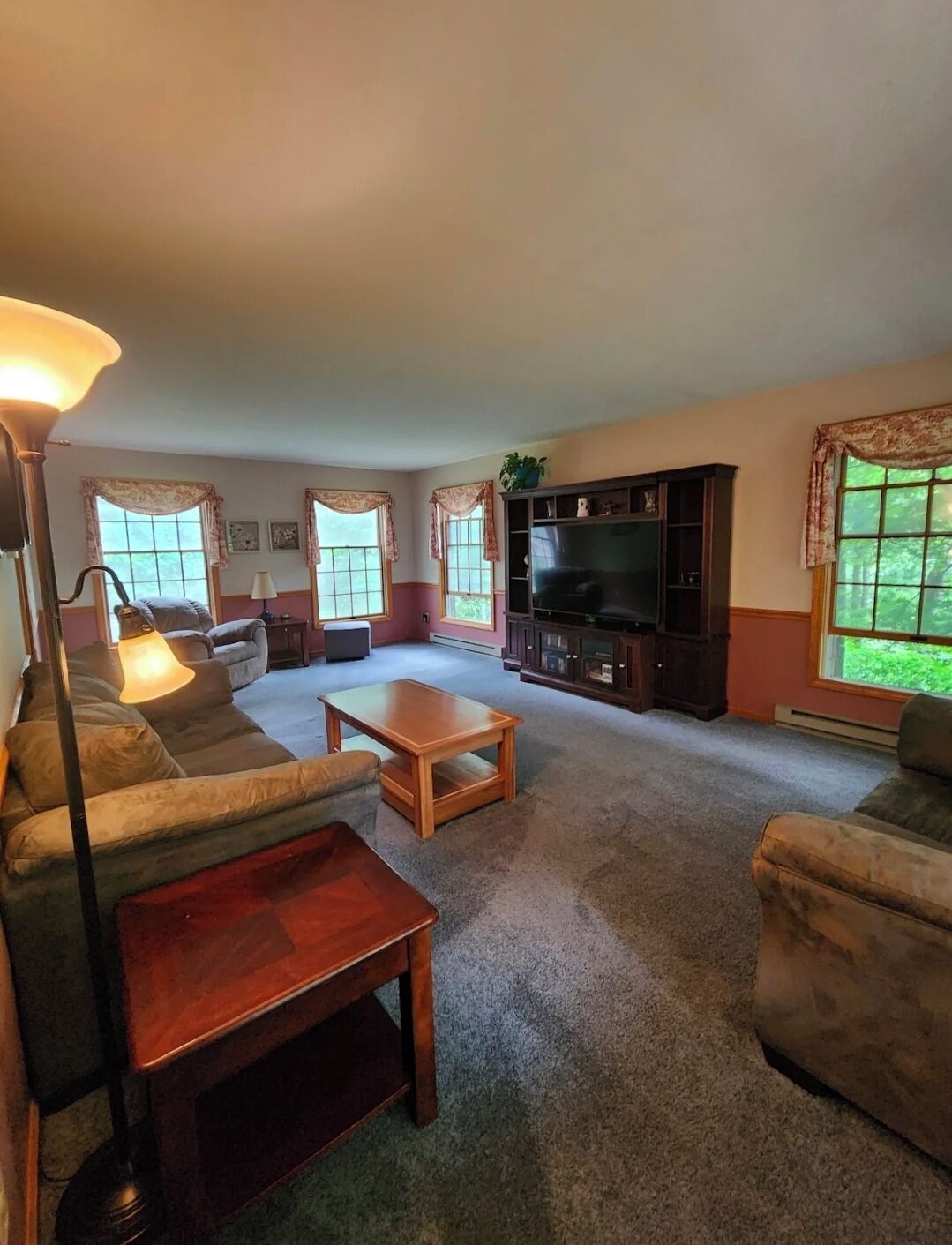 A living room with a sofa, a coffee table, a TV stand, and a lamp.