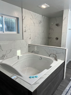 Shower, jetted tub, towels, toilet paper