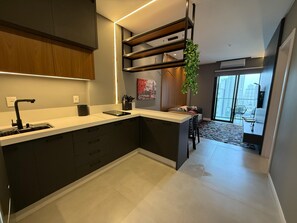 Una cocina moderna con una isla integrada, un fregadero y una zona de comedor con una silla.