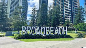 Naamplaatje voor Victoria Park en Broadbeach, omgeven door moderne hoogbouw.