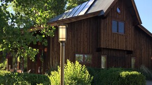A wooden cabin with a sloped roof, a lantern post, and a stone pathway leading to the entrance. - Spacious cabin and studio in beautiful Mancos with AC and heat (Mancos)