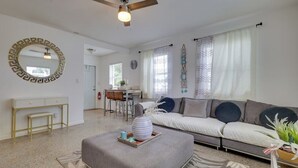 Ένα σαλόνι με έναν καναπέ, ένα πουφ και ένα γραφείο με μια καρέκλα.