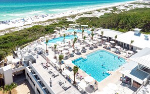 Ein Resort mit großem Pool, Liegestühlen und Blick auf den Strand.