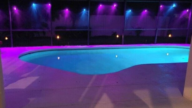 A swimming pool with a curved edge, surrounded by a deck. - 333 Burford Circle Davenport (Davenport)