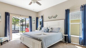 A bedroom with a bed, a ceiling fan, a window with curtains, and a view of the outside. - 333 Burford Circle Davenport (Davenport)