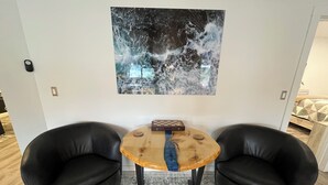 A room with two black leather chairs, a small wooden table with a chessboard, and a large abstract painting on the wall. - Apartment E: Car Rental Option
2 bed 2 bath centrally located in lovely Sitka! (Sitka)