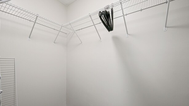 A laundry room with a metal drying rack, a white door, and a carpeted floor. - 23 Magnolia, Rydal (Rydal)