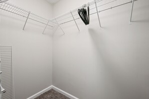 A laundry room with a metal drying rack, a white door, and a carpeted floor. - 23 Magnolia, Rydal (Rydal)