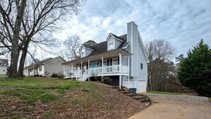 A two-story house with a front porch, a chimney, and a driveway leading to the garage. - 23 Magnolia, Rydal (Rydal)
