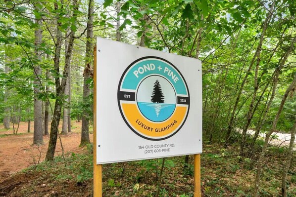 A sign for POND + PINE Luxury Glamping at 154 Old County Rd. - A Serene A-frame Cabin With Hot Tub (Oxford)