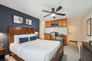 Ein Schlafzimmer mit einem großen Bett, einem Holz-Kopfteil und einem Deckenventilator.