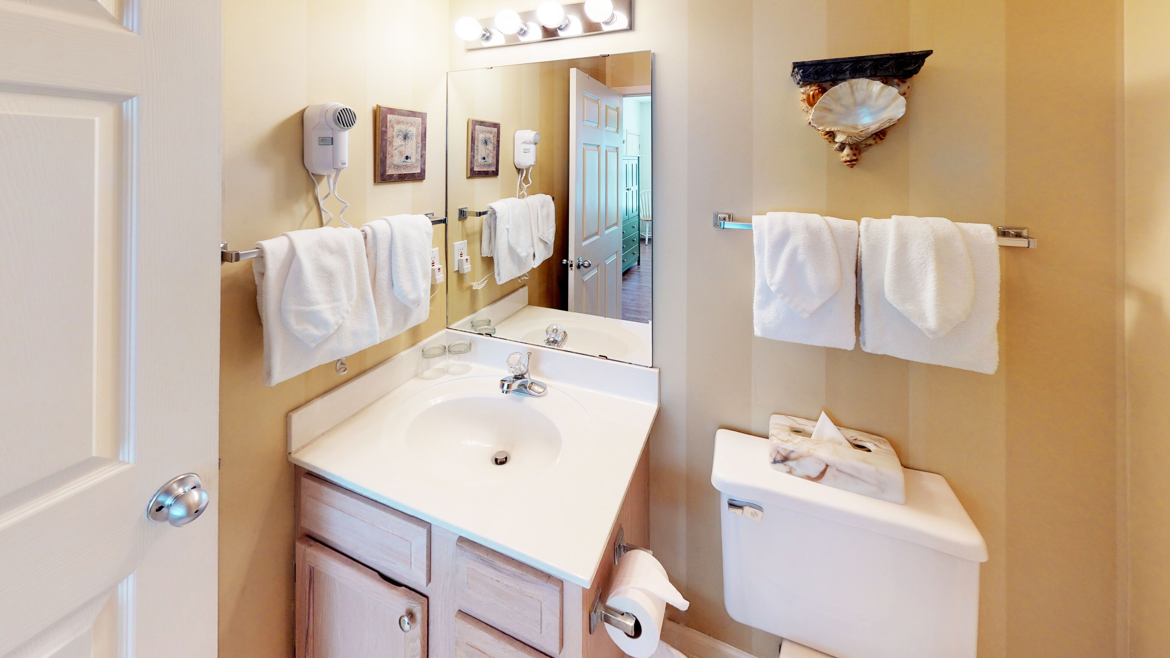 A bathroom with a sink, mirror, towel rack, and toilet.
