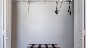 A walk-in closet with a wooden bench, a metal rack, and a hanging rack. - Pet-friendly 3BR 2BA Quiet Comfort Near Nature (Rydal)