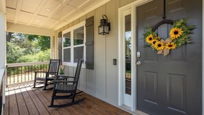 A porch with two rocking chairs and a door with a sunflower wreath. - Pet-friendly 3BR 2BA Quiet Comfort Near Nature (Rydal)