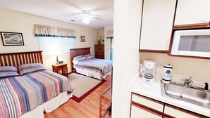 A bedroom with two beds, a nightstand, a lamp, and a window with curtains. - River Creek 1 Unit 401 (Sunset Beach)