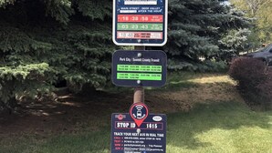 A bus stop sign with a bus icon, a phone number, peak hours, and a stop ID. - Prime Spot! Walk to Ski, Shops, and Main Street! (Park City)