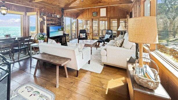 A wooden interior with a TV, sofa, and dining area. - Seacoast Sanctuary (Cape Neddick)