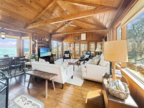 Un interior de madera con televisor, sofá y comedor.