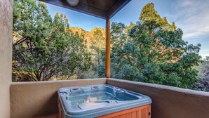 Ein Whirlpool auf einem Balkon mit Blick auf Bäume und ein Berg.
