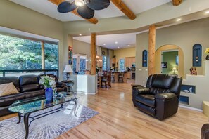 A spacious living area with a glass coffee table, leather sofas, and a kitchen in the background. - Sedona Quail Haven (Sedona)