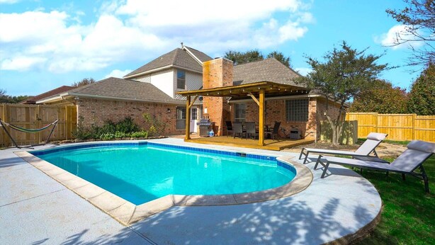 A backyard with a swimming pool, a covered patio, and lounge chairs. - The Prestige Poolside Escape - 5BR w Cinema & Gaming (DeSoto)