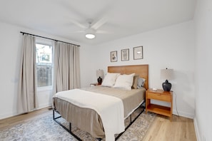 A bedroom with a bed, bedside tables, a ceiling fan, and a window with curtains. - Stylish Nashville Getaway With Free Parking (Nashville)