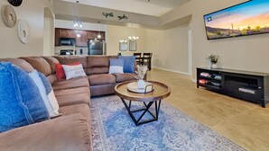 A modern living room with a brown leather sofa, a round coffee table, and a flat-screen TV mounted on the wall. - Southern #3116 Mesa (Mesa)