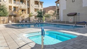 A swimming pool area with a hot tub, lounge chairs, and a fenced poolside. - Southern #3116 Mesa (Mesa)