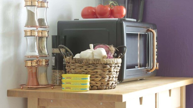 A vintage radio, a basket with vegetables, and a box of Cento pasta on a wooden surface. - Stylish Retro Vibes Private BBQ & Beach Access (Sarasota)